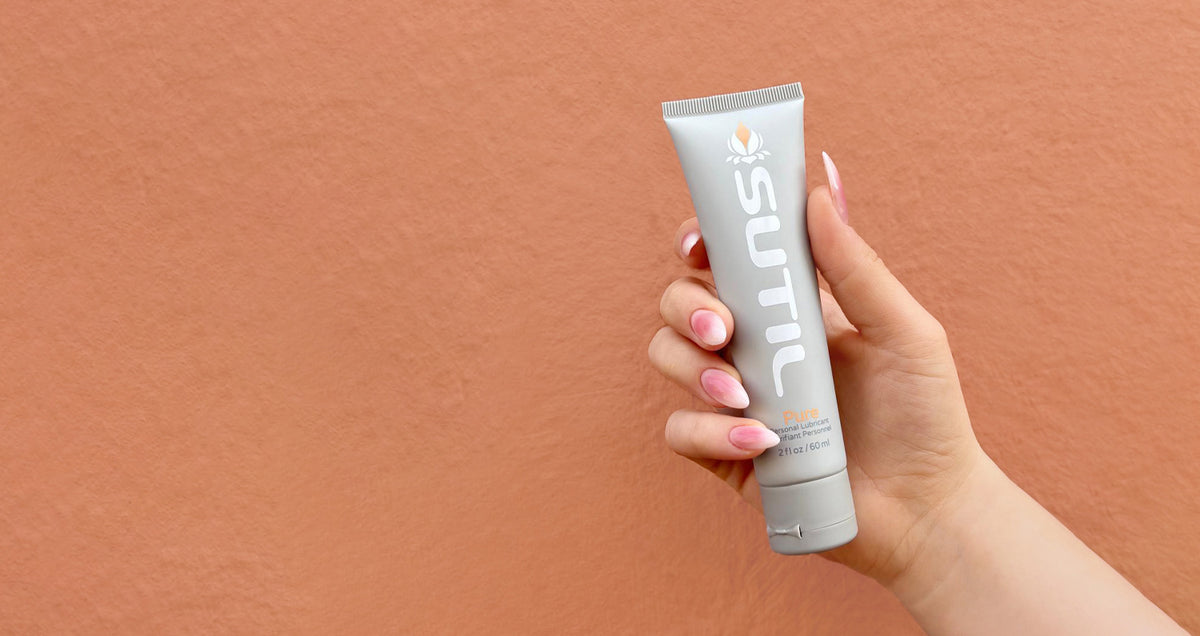 Sutil Pure held in hand on an orange background